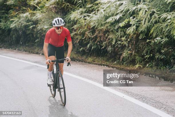 asian chinese professional cyclist athlete sportsman sprinting cycling in rural area - road cycling stock pictures, royalty-free photos & images