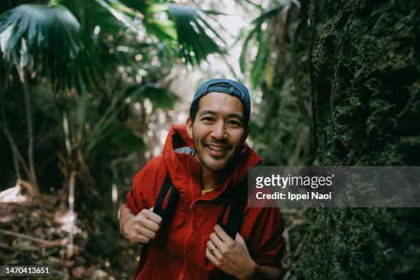man hiking through ravine in forest - アウトドア　日本人 ストックフォトと画像