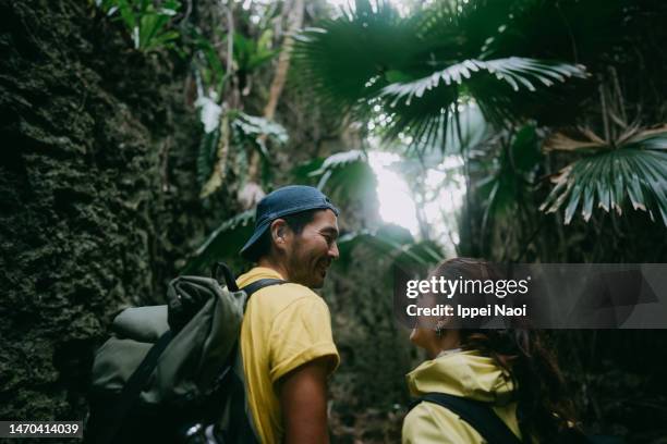 happy couple exploring cave in forest - backpacker asia stock pictures, royalty-free photos & images