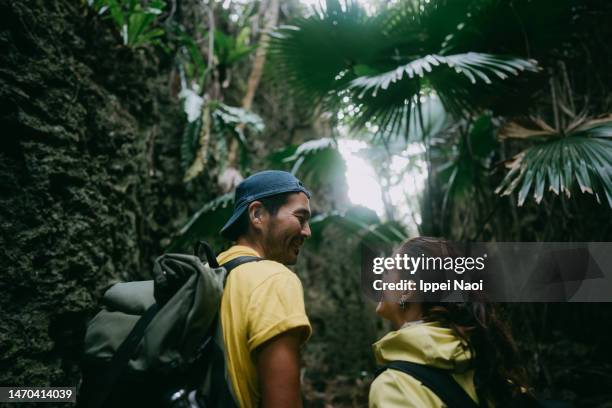 happy couple exploring cave in forest - jungle explorer stock pictures, royalty-free photos & images