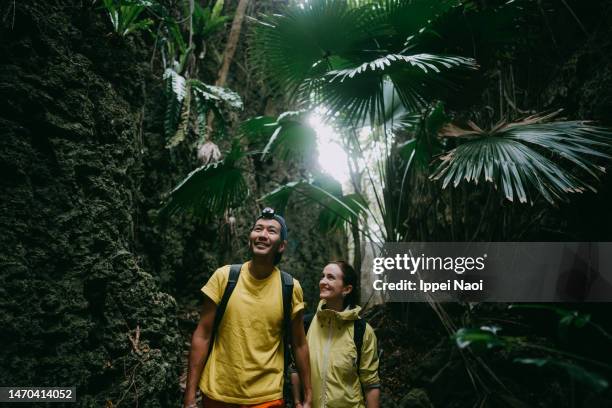 cheerful couple exploring cave in forest - selective focus imagens e fotografias de stock
