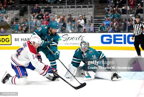 Nick Suzuki of the Montreal Canadiens shoots the puck against Mario Ferraro and goalie Kaapo Kahkonen of the San Jose Sharks during the third period...