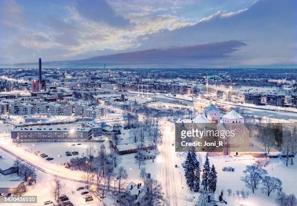aerial: view of turku castle and the city skyline in winter night in turku, finland - turku stock pictures, royalty-free photos & images