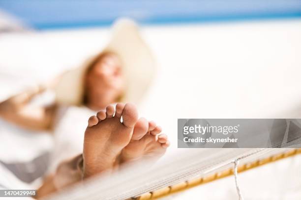 feet of a woman relaxing in hammock on the beach. - barefoot stock pictures, royalty-free photos & images