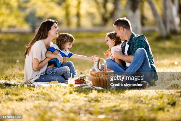 fröhliche familie kommunikation am frühlingstag im park. - brotzeit stock-fotos und bilder