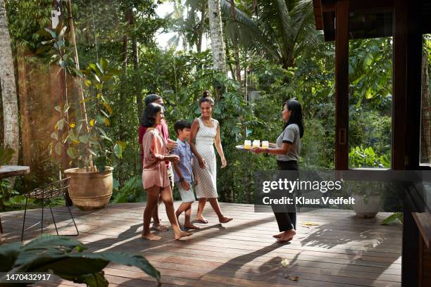 waitress welcoming guests with welcome juice at resort - holiday greeting stock pictures, royalty-free photos & images