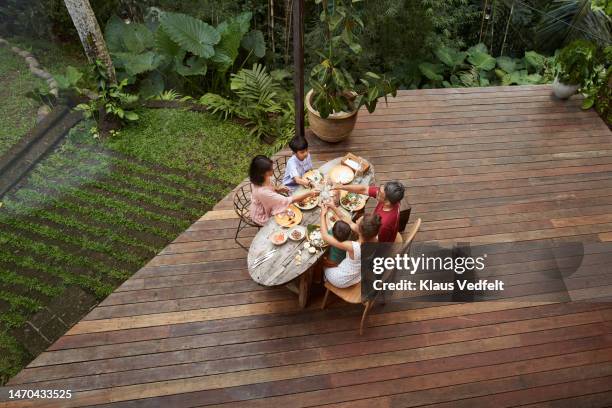 family toasting drinks on porch at resort - real family stock pictures, royalty-free photos & images