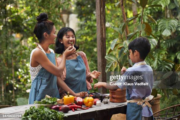 mother feeding daughter during vacation - bali stock pictures, royalty-free photos & images
