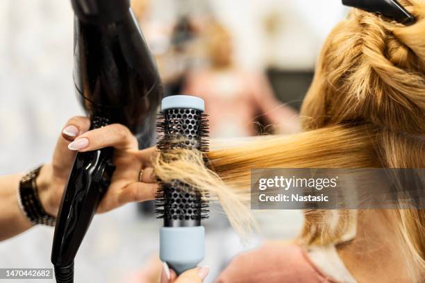 hairdresser making lock of hair - hair dryer stock pictures, royalty-free photos & images