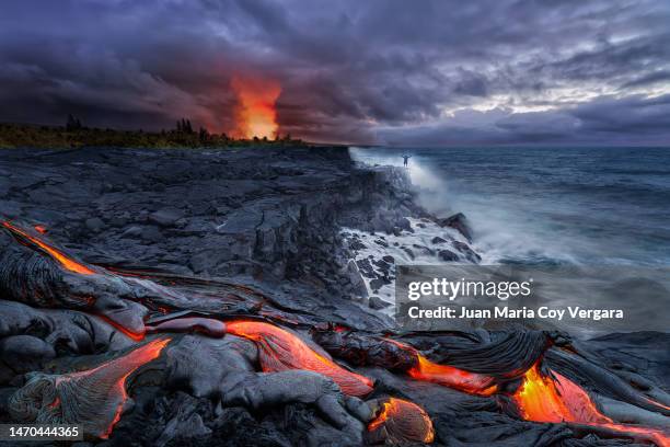 close-up of lava flowing from a rock column and pours into a volcanic landscape, kalapana, hawaii volcanoes national park, kilauea volcano, big island - hawaii islands - volcanic terrain ストックフォトと画像