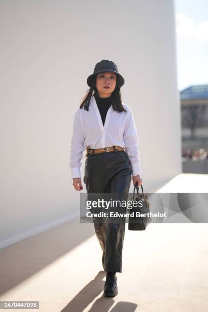 May Berthelot wears a black shiny leather embossed quilted pattern bob from Dior, a black wool turtleneck pullover from Theory, a white shirt from...