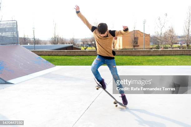 young boy riding skateboard at skatepark - performing tricks stock pictures, royalty-free photos & images