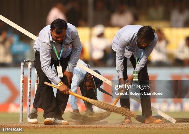 The pitch is swept at the drinks break during day one of the Third Test match in the series between India and Australia at Holkare Cricket Stadium on...