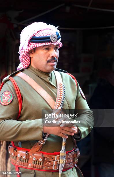 single smartly uniformed and decorated jordanian officer stands at end of al siq canyon, petra, jordan, middle east. - jordan middle east stock pictures, royalty-free photos & images