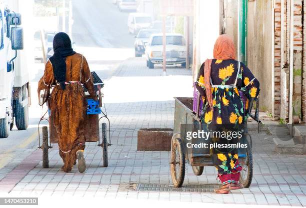 unidentifiable street cleaners in colourful traditional wear, madaba, central jordan - amman jordan stock pictures, royalty-free photos & images
