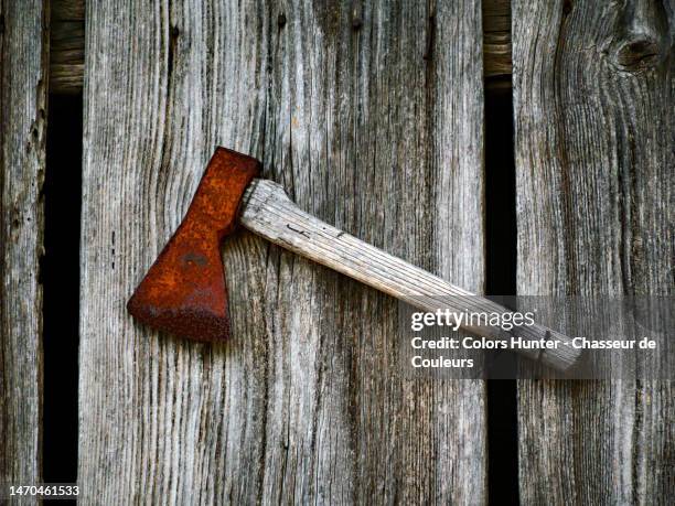 a rusty and weathered ax on an old plank wall in evian-les-bains - assassination fotografías e imágenes de stock