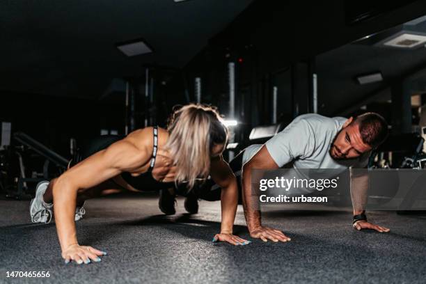 young couple exercising together at the gym - press ups stock pictures, royalty-free photos & images