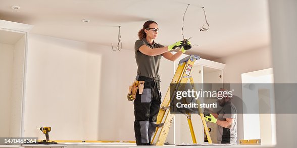 female electrician working in a kitchen remodelling