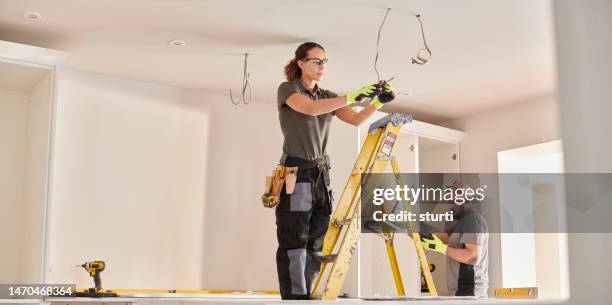 female electrician working in a kitchen remodelling - electrician 個照片及圖片檔