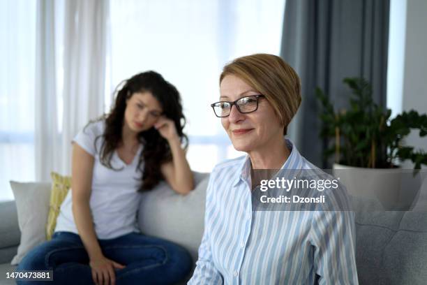 young woman sitting and talking to her psycologist during consultation - mental health awareness month stock pictures, royalty-free photos & images