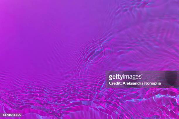 ethereal dark holographic purple, pink, blue transparent water surface texture with ripples, splashes, waves - nightclub bathroom stockfoto's en -beelden