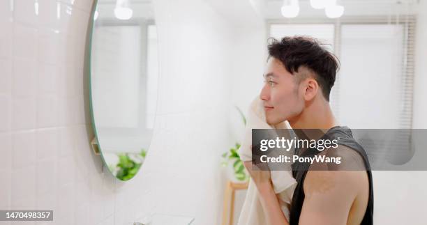 man wiping face with towel - creme de limpeza facial imagens e fotografias de stock