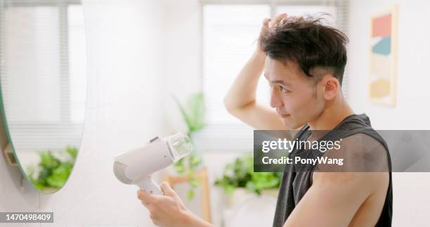 asiatischer mann verwenden haartrockner - drying hair stock-fotos und bilder
