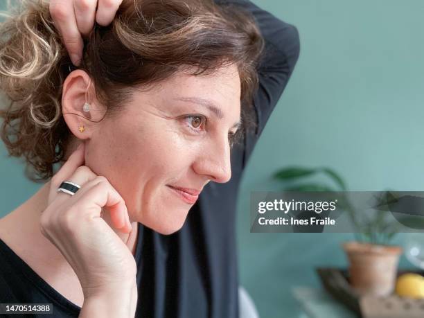 smiling woman showing her correctly placed hearing aid - prophylaxie stock pictures, royalty-free photos & images