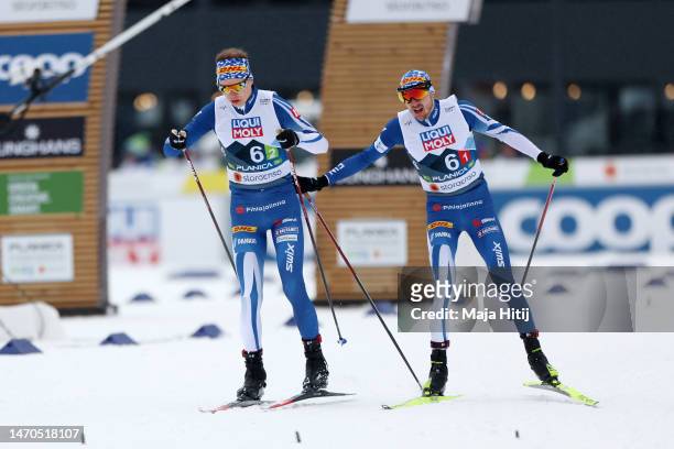 Ilkka Herolan of Team Finland changes over to Arttu Maekiaho of Team Finland during the cross country leg of Nordic Combined Men's Team Large Hill...