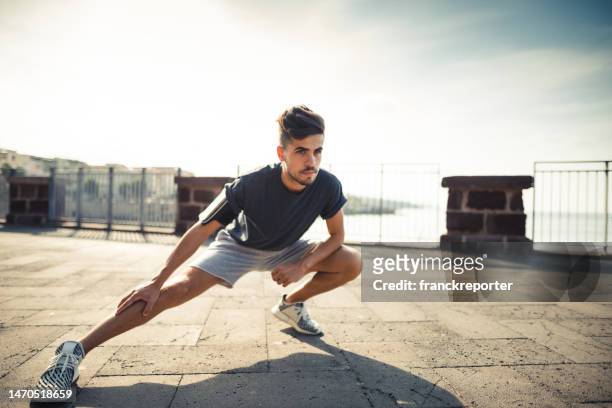 man doing stretching in the city - south africa v italy stock pictures, royalty-free photos & images