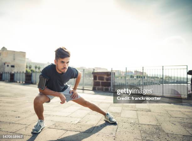 man doing stretching in the city - south africa v italy stock pictures, royalty-free photos & images