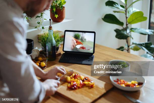 handsome man preparing a meal at home following an online recipe (copy space) - following recipe stock pictures, royalty-free photos & images