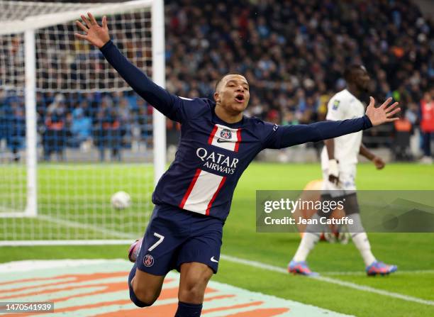 Kylian Mbappe of PSG celebrates his second goal while Eric Bailly of Marseille looks on during the Ligue 1 match between Olympique de Marseille and...