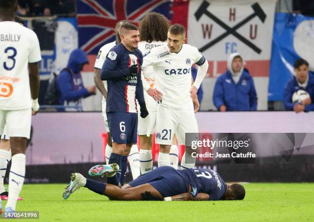 Marco Verratti of PSG, Valentin Rongier of Marseille react to the serious injury of Presnel Kimpembe of PSG lying down during the Ligue 1 match...