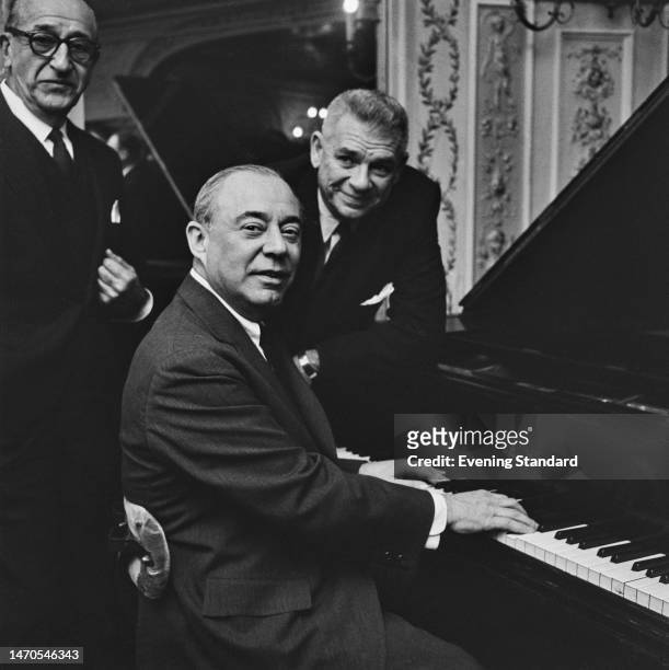 American playwright Joseph Fields , songwriter Richard Rogers at the piano and librettist Oscar Hammerstein II , promoting their show 'Flower Drum...