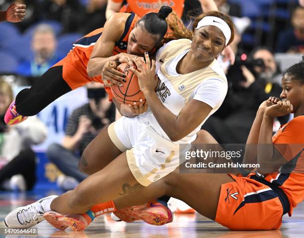 Taylor Valladay of the Virginia Cavaliers wrestles for the ball with Demeara Hinds of the Wake Forest Demon Deacons during the first half of their...