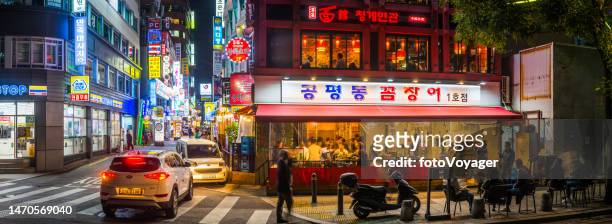warmly illuminated street restaurant neon night city panorama seoul korea - korean language stock pictures, royalty-free photos & images