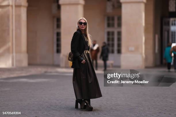 Corina Mihaila Larpin seen wearing black long Rosetta Getty leather dress, black Alaia jacket, black Yves Saint Laurent plateau boots, gold...
