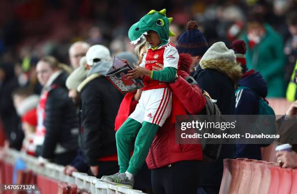 Young Arsenal fan reads the programme ahead of the Premier League match between Arsenal FC and Everton FC at Emirates Stadium on March 01, 2023 in...