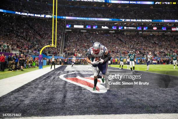 Rob Gronkowski of the New England Patriots makes a catch for a touch down even though he is tackled by De'Vante Bausby of the Philadelphia Eagles...