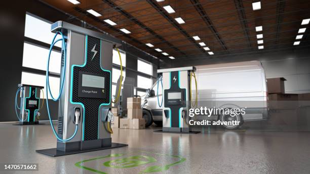 electric commercial vehicles, industrial charging stations and stack of cargo boxes inside a distribution warehouse - electricity stockfoto's en -beelden