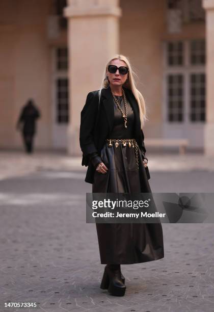 Corina Mihaila Larpin seen wearing black long Rosetta Getty leather dress, black Alaia jacket, black Yves Saint Laurent plateau boots, gold...