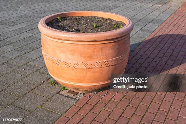 large round orange colored pottery pot standing on the street - le big bazar foto e immagini stock