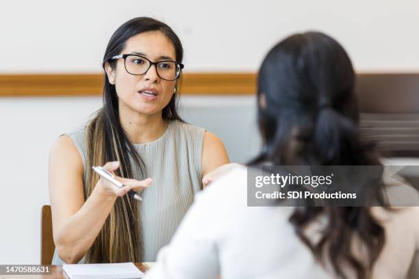 mental health therapist meets with her client in the conference room - mentor imagens e fotografias de stock