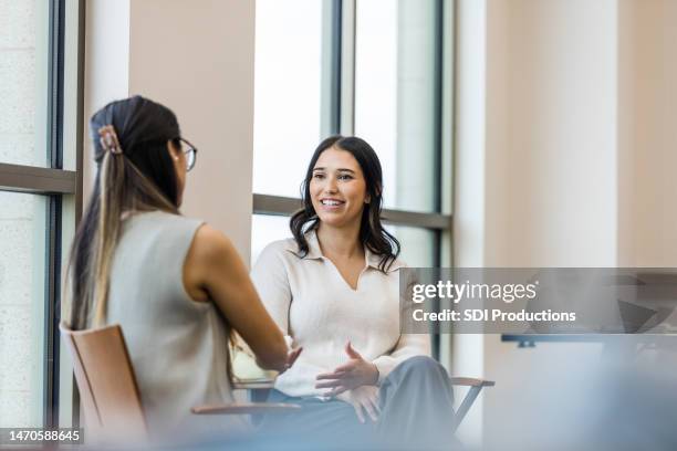 le colleghe si siedono e si godono la conversazione dopo il lavoro - mentoring foto e immagini stock