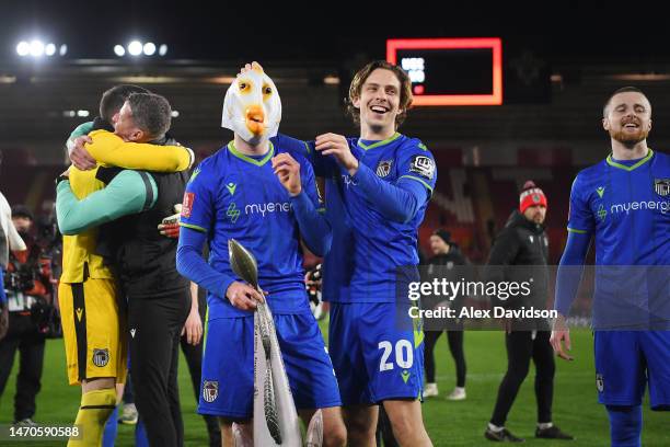 Anthony Driscoll-Glennon of Grimsby Town celebrates victory by wearing a fish mask and holding Harry Haddock an inflatable fish at full time...