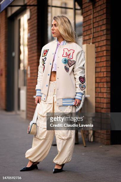 Emma Bonneaud wears a cream decorated bomber jacket, parachute cream pants, pink striped cropped shirt and Diesel bag, outside Victoria/Tomas, during...
