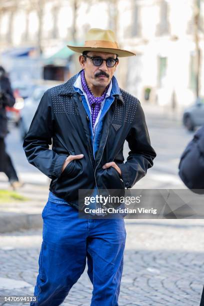 Haider Ackermann wears hat, black jacket, blue pants outside Undercover during Paris Fashion Week - Womenswear Fall Winter 2023 2024 : Day Three on...