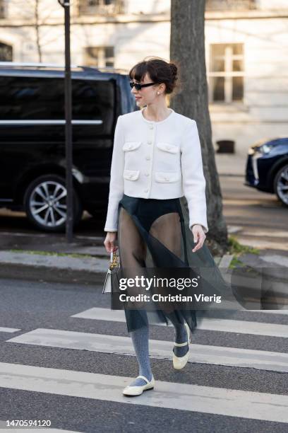 Mary Leest wears transparent skirt, white jacket, Fendi bag, grey knee high socks outside Cecilie Bahnsen during Paris Fashion Week - Womenswear Fall...