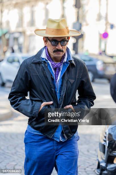 Haider Ackermann wears hat, black jacket, blue pants outside Undercover during Paris Fashion Week - Womenswear Fall Winter 2023 2024 : Day Three on...